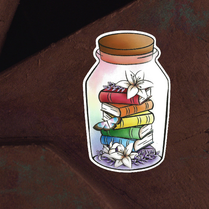 Small books, colors of the LGBTQIA+ pride flag, are in a little bottle